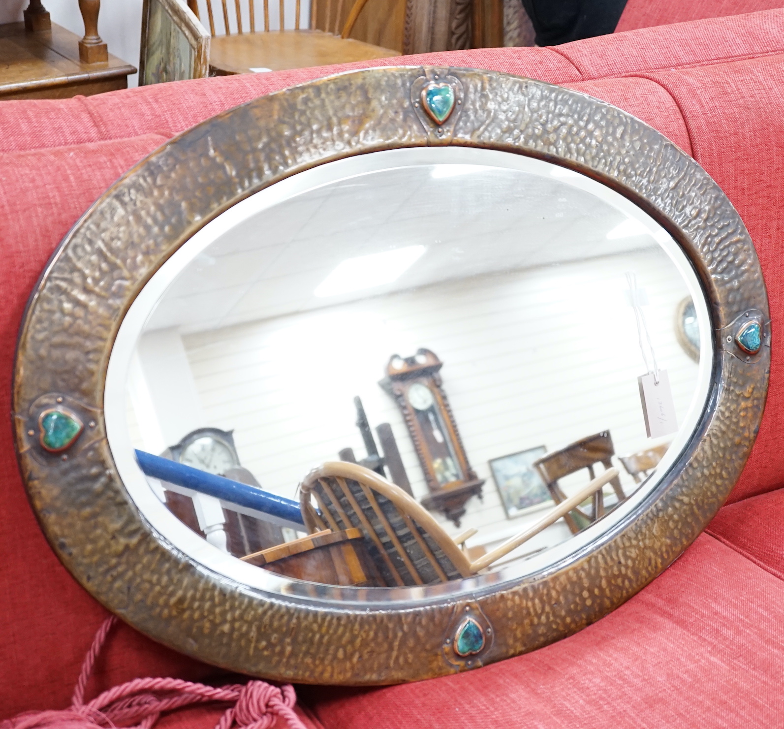 An Arts and Crafts style hammered copper mirror, width 86cm height 60cm